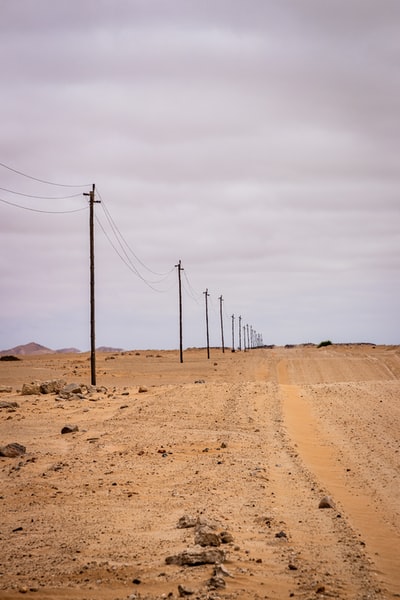 During the day, the sky white brown brown wooden pole on the beach
